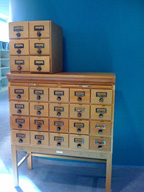 Archivadores de fichas de color beige sobre una pared azul.
