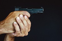 Manos empuñando un arma.