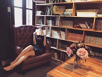 Mujer leyendo un libro en un sofá.