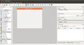 Imagen que muestra una captura de pantalla de la herramienta QT Designer con sus menús, y paneles a izquierda y derecha del lienzo, formado por un formulario en blanco preparado para ser diseñado.