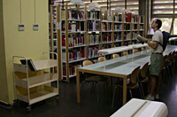 Chico en una biblioteca consultando un libro.