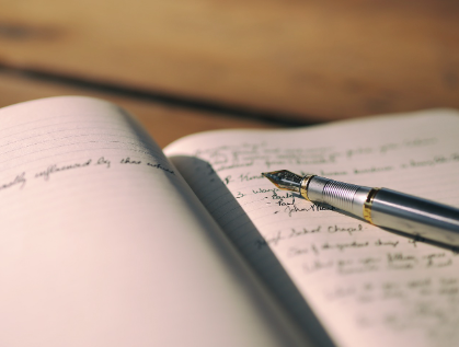 Imagen de una pluma sobre una libreta