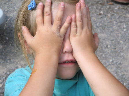 Imagen de una niña tapándose los ojos