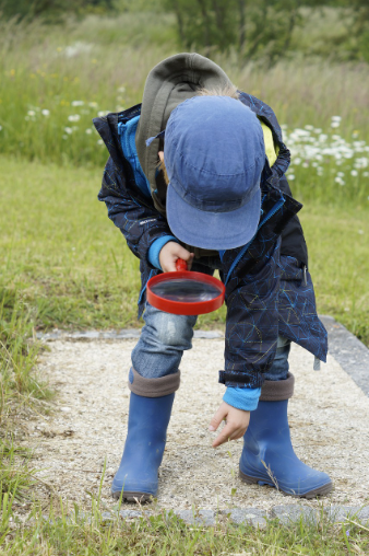 Imagen de un niño inspeccionado con una lupa