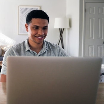 Hombre sonriente trabajando con su portátil.