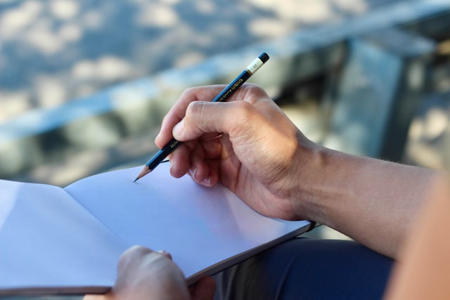 Persona modelando un Entidad-Relación en un cuaderno al aire libre.