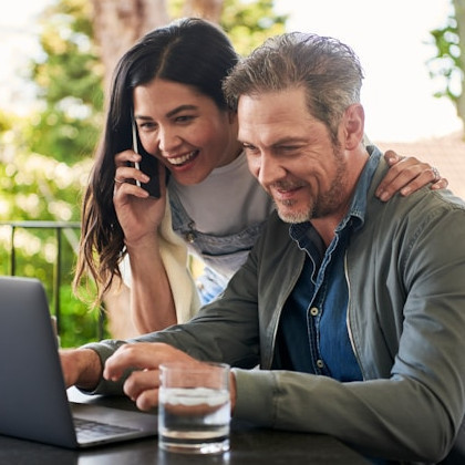 Mujer y hombre contentos trabajando con su portátil.