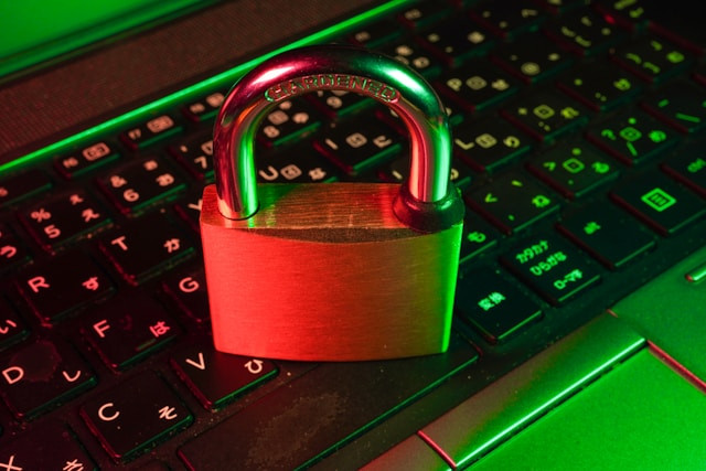 Candado cerrado colocado en un teclado iluminado en tonos verdes y rojos.
