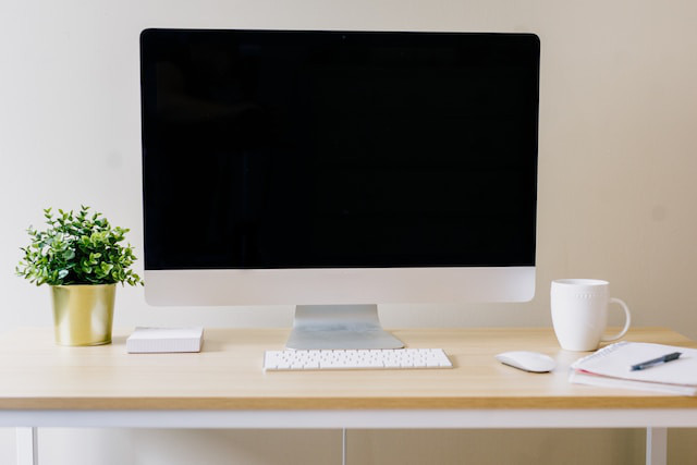 Escritorio con un ordenador y diferentes elementos de decoración.