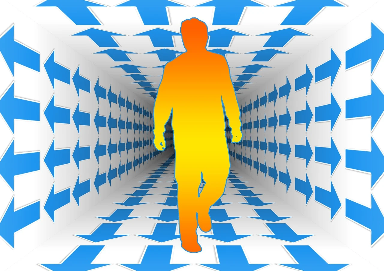 Persona caminando por un túnel rodeado de flechas indicadorass