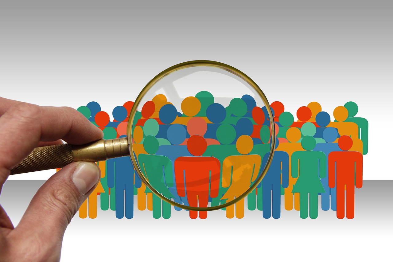 Personajes de colores en grupo ampliados por una lupa