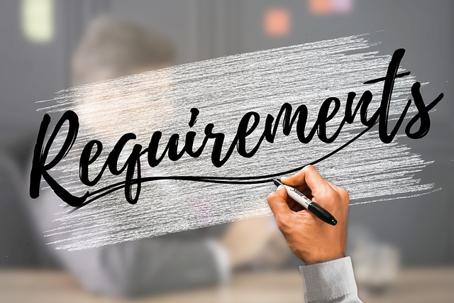 En la imagen se visualiza una mano escribiendo la palabra requisitos (requirements) en ingles. 