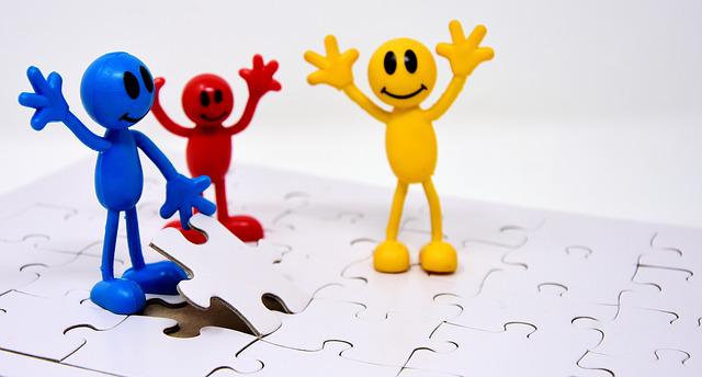 Tres muñecos encajando piezas en puzzle.