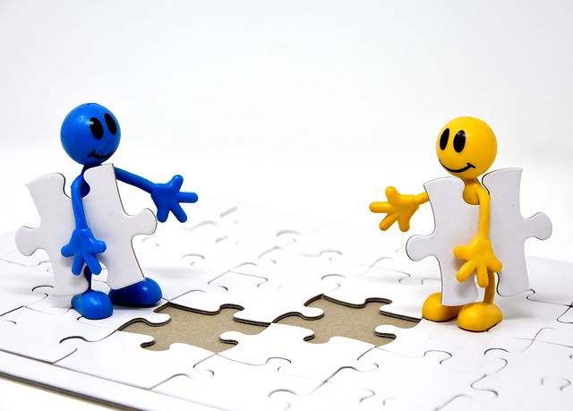 Dos muñecos encajando piezas en puzzle.