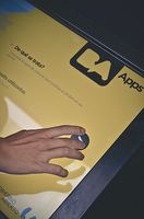 Una mano interacciona con una pantalla sobre la que se ve escrita la abreviatura de la palabra aplicaciones, Apps. 