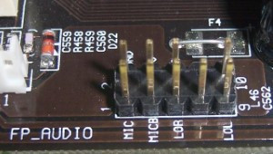 Se muestra un grupo de pines que salen de la placa base, en los que deben insertarse los cables que vienen del frontal para conectar microfono y altavoces.