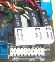 Muestra el conector auxiliar con los cablecitos del frontal conectados  a punto de ser insertado en el conector de la placa base.