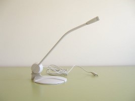 Pequeño micrófono domestico situado en su peana y con su cable de conexión.