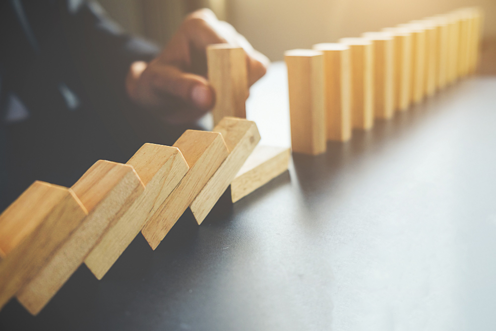 Hilera de fichas representando el riesgo en cadena