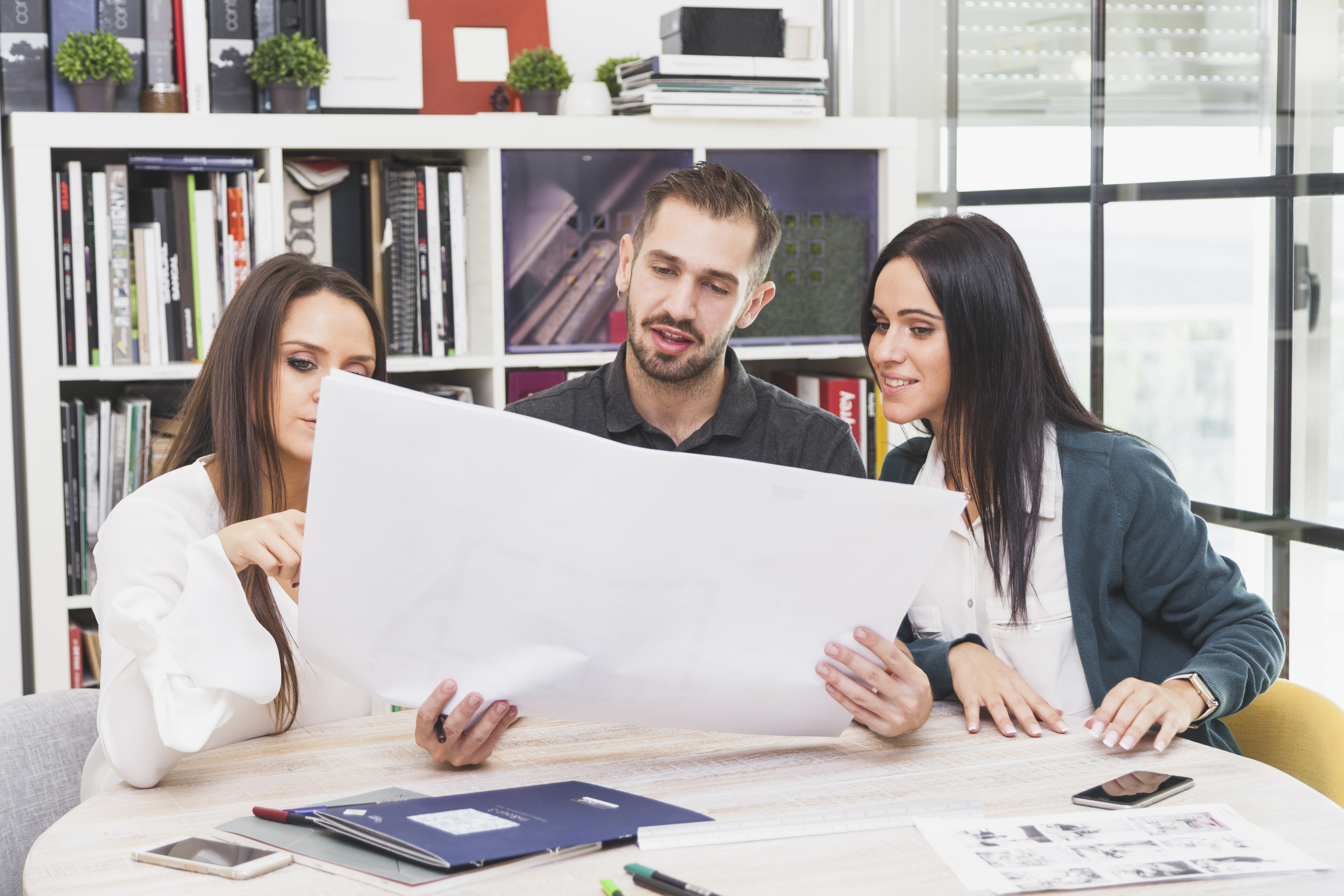 Tres personas conversando sobre un informe